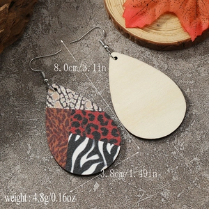 Detail view of teardrop wooden earrings featuring mixed leopard and zebra animal prints