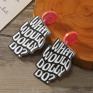 Detail of red glitter acrylic earrings with What Would Dolly Do text on wood background