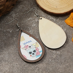 Details von Tropfenohrringen aus Holz mit Blumen-Skull- und Western-Bovinemuster