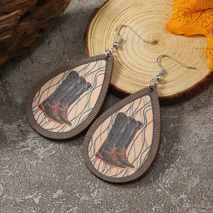 Detail von tropfenförmigen Holzohrringen mit Retro-Cowboystiefel-Druck und Silberhaken