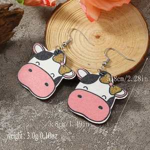 Detailed view of cow-shaped earrings with pink bows and dimensions 5.8cm by 3.8cm