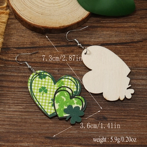 Detalle de pendientes de madera en forma de corazón con tréboles y medidas de tamaño