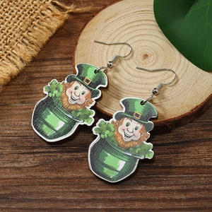 Close-up of wooden St. Patrick's Day earrings with Leprechaun and clover on burlap