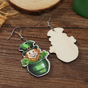 Close-up of wooden St. Patrick's Day earrings with cartoon leprechaun and pot of clovers