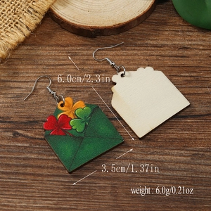 Detalle de pendientes de madera con forma de sobre, tréboles, tamaño y textura natural