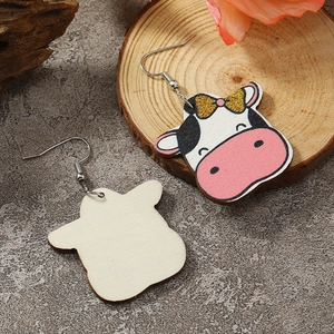 Detail view of cute cow wooden earrings showing painted front and natural wood texture back