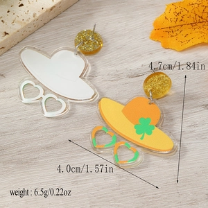 Detail of acrylic earrings with shamrock hat and heart sunglasses on a wooden background