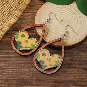 Detalle de pendientes de madera de San Patricio con trébol verde y diseño de corazón