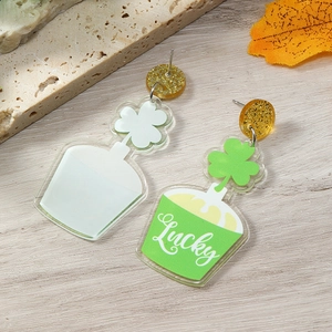 Macro view of St. Patrick's Day acrylic lucky clover earrings with gold glitter accents