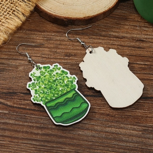 Detalle de pendientes de madera de San Patricio con estampado de trébol verde y textura natural