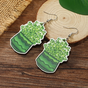 Detalle de pendientes de madera con forma de planta verde y diseño festivo de San Patricio