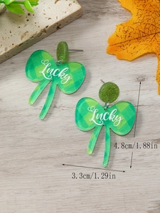 Detalle de pendientes de acrílico a cuadros verdes con texto Lucky y brillo superior