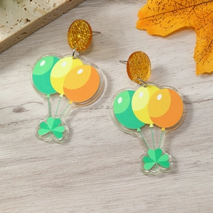Detail of St. Patrick's Day acrylic earrings with shamrock, balloons, and orange glitter studs