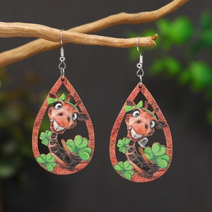 Detail of wooden teardrop earrings with giraffe and shamrock pattern on branch