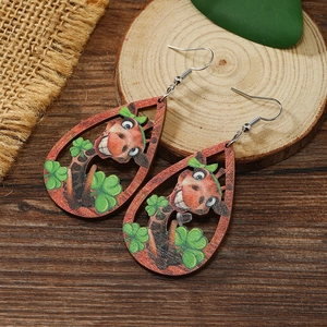 Detailed view of teardrop wooden earrings featuring cartoon giraffe and clover patterns