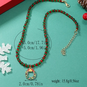Detail van rood-groene kralenketting met kerstkrans-hanger en gouden verlengketting