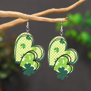 Detalle de pendientes de madera con forma de corazón y patrones de trébol verde