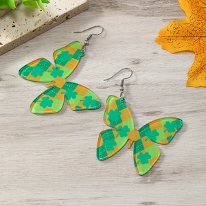 Detalle de pendientes de mariposa con tréboles verdes para el día de San Patricio
