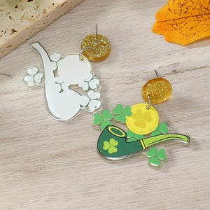 Detail of St. Patrick's Day acrylic earrings with shamrock pipe and gold coin charms