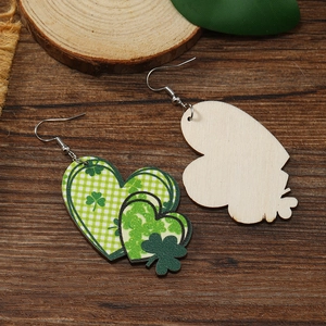 Detalle de pendientes de corazón en madera de San Patricio con tréboles verdes
