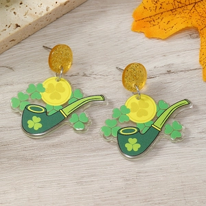 Detail view of St. Patrick's Day acrylic earrings with shamrock coins on wood background