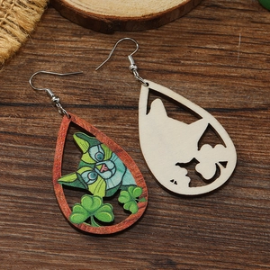 Detail of wooden teardrop earrings with green cat and four-leaf clover graffiti art