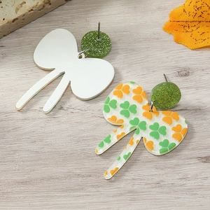 Detalle de pendientes de lazo de acrílico de San Patricio con purpurina verde y tréboles