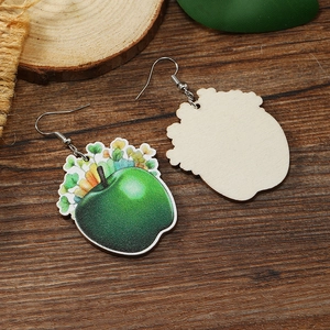 Detalle de pendientes de madera con estampado floral de manzana verde sobre madera oscura
