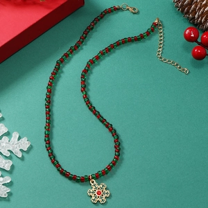 Detail van kerstparelketting met gouden sneeuwvlok hanger op een feestelijke achtergrond