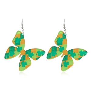 Detalle de pendientes de mariposa con trébol y patrón de cuadros verdes para fiesta
