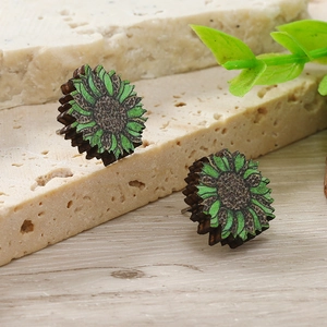 Dettaglio di orecchini a lobo in legno a girasole con petali verdi e stampa leopardata