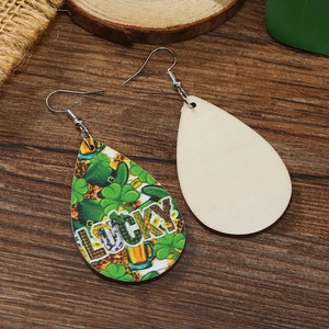 Macro shot of St. Patrick’s Day wooden teardrop earrings with lucky clover and leopard print