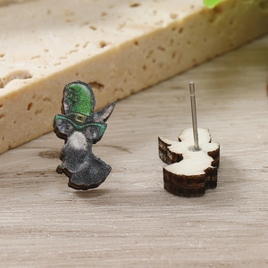 Dettaglio della trama in legno e del design dello gnomo glitterato degli orecchini