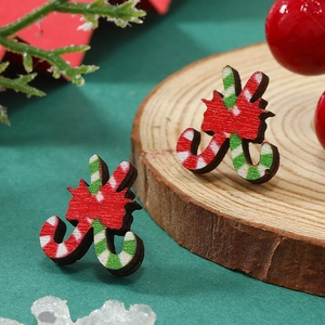 Pendientes de madera de Navidad bastón de caramelo con lazo sobre fondo festivo