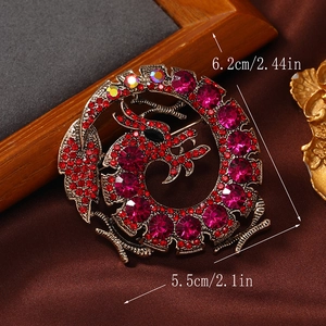 Detailed size view of a retro dragon brooch with red rhinestones, 6.2cm by 5.5cm