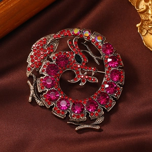 Vintage gold dragon brooch with red crystals on a dark satin background for suits