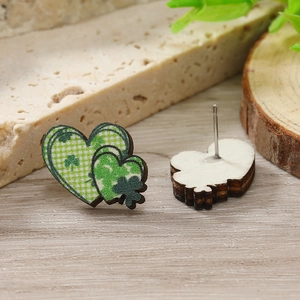 Dettaglio macro di orecchini a cuore in legno per San Patrizio con trifogli verdi