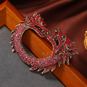 Macro shot of detailed enamel Chinese dragon brooch with vibrant red and pink crystals