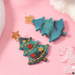 Detail of Christmas tree resin earrings with marble texture and star studs on pink background
