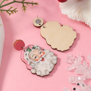 Detail of vintage Santa Claus wooden earrings showing front and back on pink background