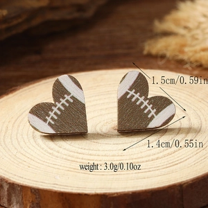 Detail showing the size and weight of heart-shaped rugby patterned wooden stud earrings