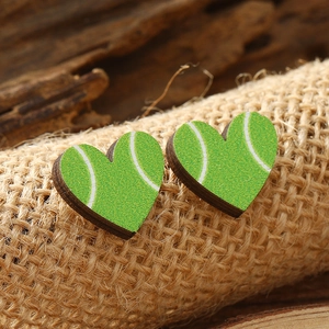 Macro shot of heart-shaped wooden stud earrings with green tennis ball print and texture