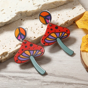 Cute colorful mushroom stud earrings with peace symbol on warm natural background