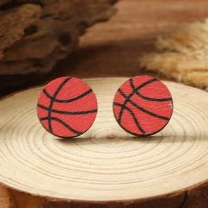 Macro shot of basketball style wooden stud earrings on a light wood display tray