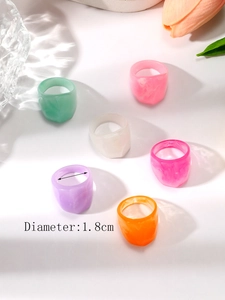 Dettaglio di anelli spessi in resina colorati con misura del diametro di 1,8 cm