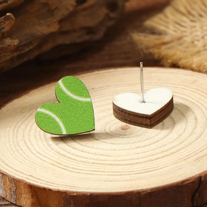 Close-up of heart-shaped tennis pattern wood stud earrings with green velvet texture