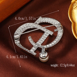 Detailed view of silver brooch with crystals and pearl, showing 4.0cm x 4.1cm size