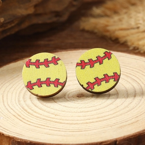 Macro shot of yellow wooden softball stud earrings with red stitching on wood background