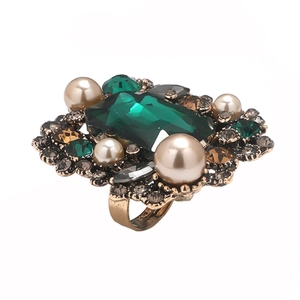 French vintage gold cocktail ring with large emerald crystal and pearls on white background