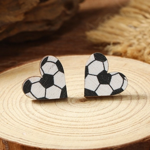 Handcrafted heart-shaped wooden earrings with a classic black and white soccer pattern